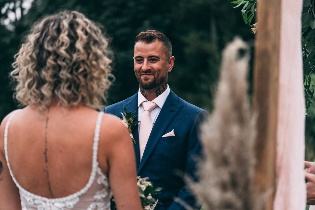 Groom looks at bride while exchanging wedding vows