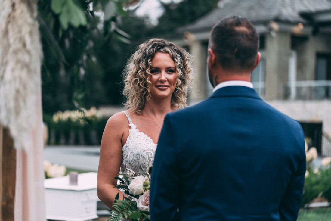 Bride looks at groom as vows are exchanged at wedding ceremony