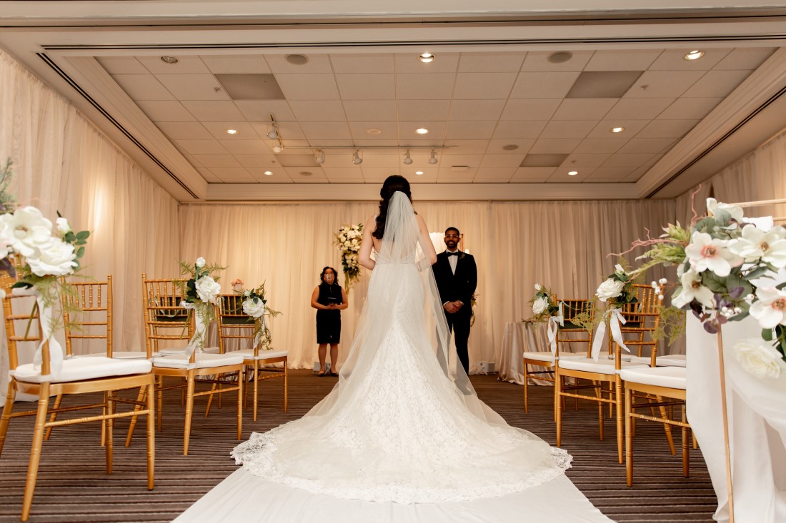 Bride walks down the aisle with train at Vancouver Hilton