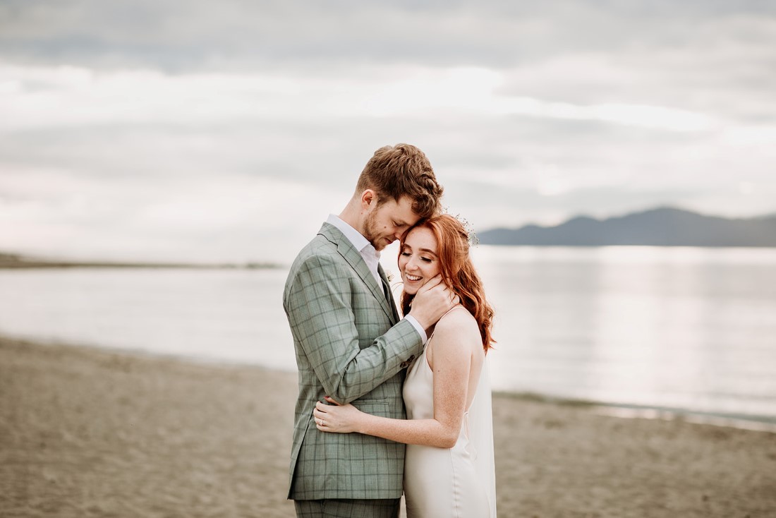 Bride and groom hugging on Vancouver beach