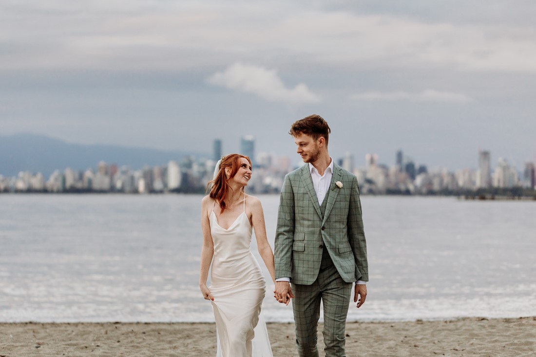 Newlyweds stand in front of Vancouver skyline by Sydney Aleisha Photography