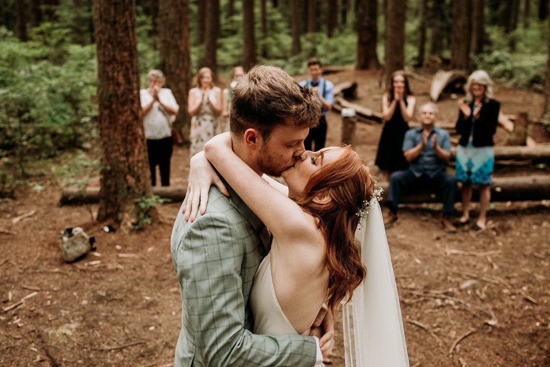 Bride and groom kiss after exchanging wedding vows in the Vancouver Forest