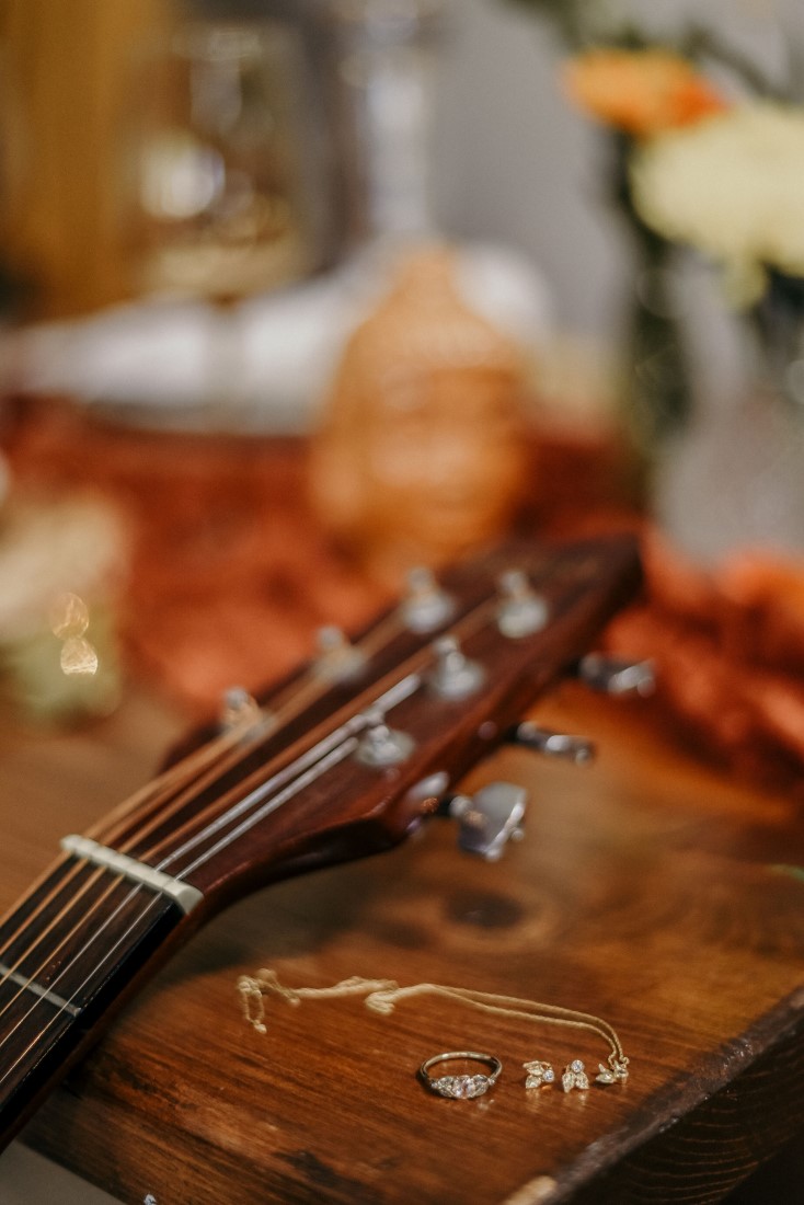 Deep Cove Winery Wedding Dayla Weiss Photo detail shot of jewelry and guitar