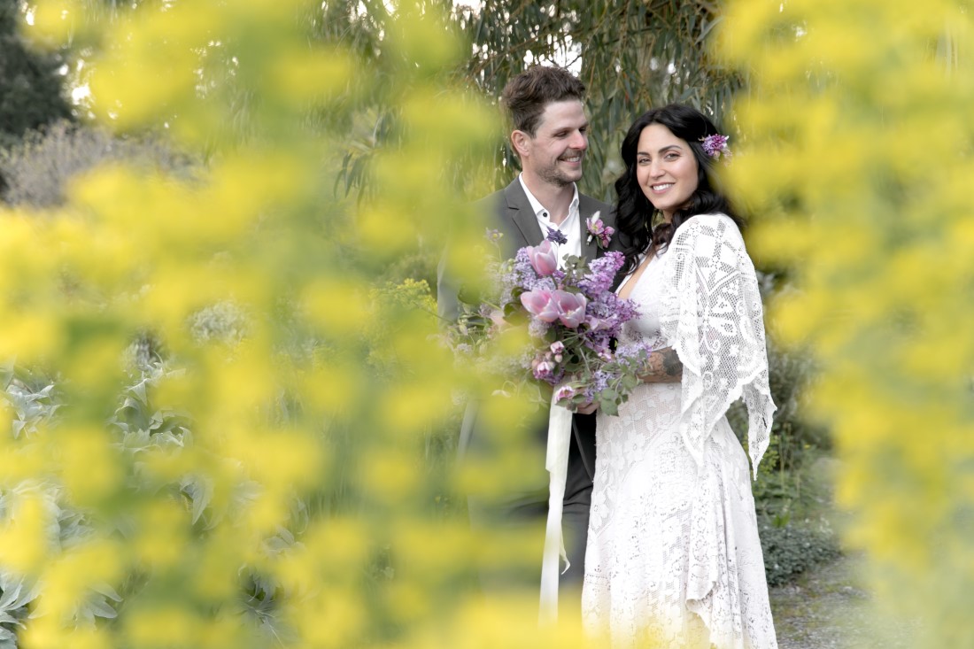 Purple Lilac Spring Wedding Hattie Root Photo groom smiling at his bride in reclamation gown