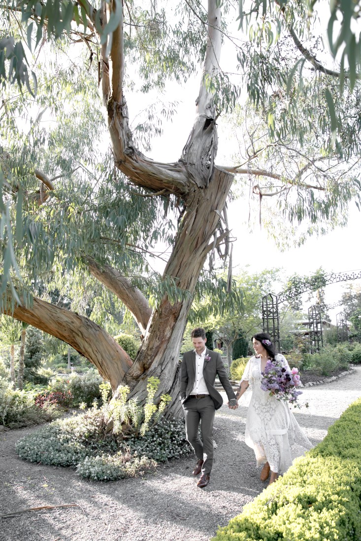 Purple Lilac Spring Wedding Hattie Root Photo bride and groom walk handing in hand