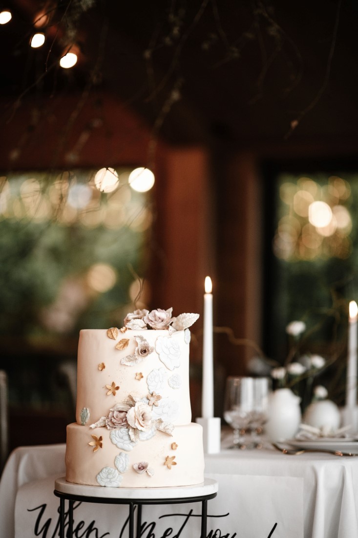 Wedding Cake by Cakebread Artisan with white icing and tall white candle at Dolphin's Resort