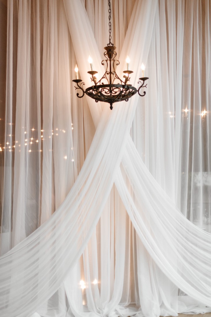 Love Letters White Drapery with Chandelier backdrop for wedding at Dolphin's Resort