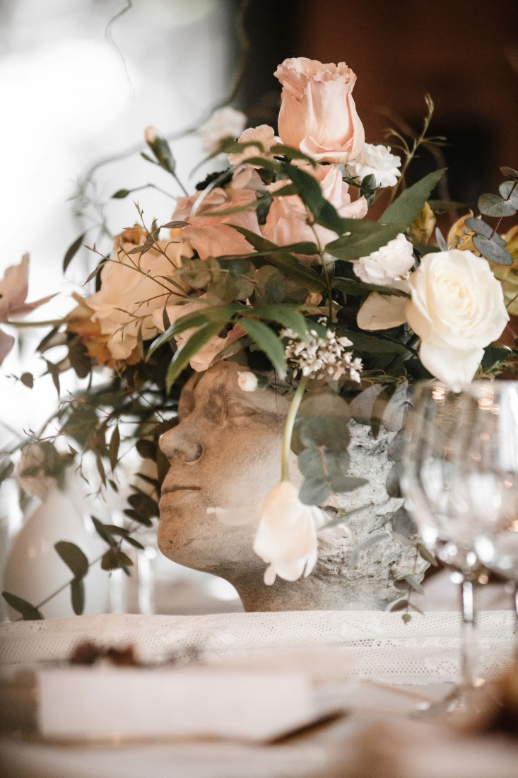 Blush flowers inside sculpture vase on wedding reception table by Erin Wallis Photography