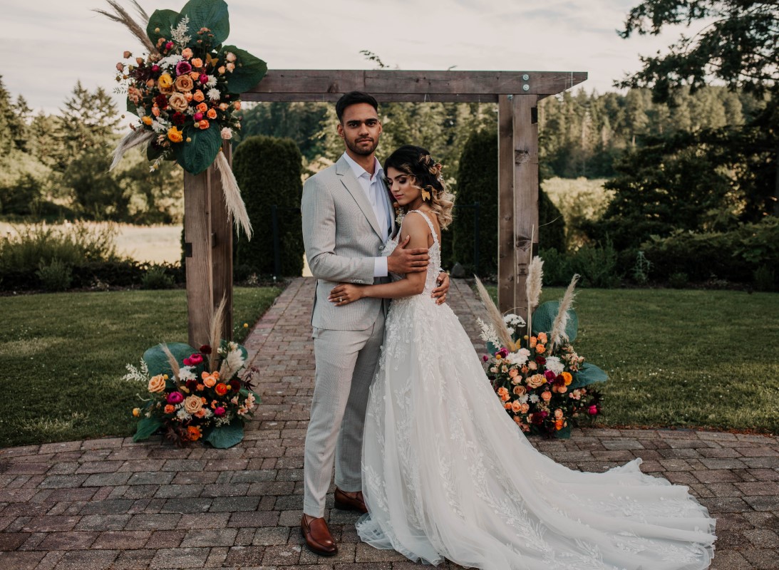 Newlyweds in front of ceremondy backdrop at HCP Gardens by Kelsey Lageri Photography