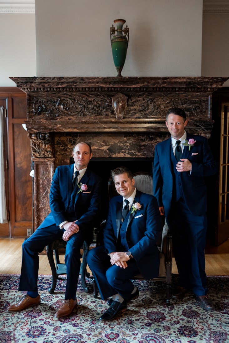 Groomsman photo in front of fireplace at Hycroft Manor by Justin Kho Photography