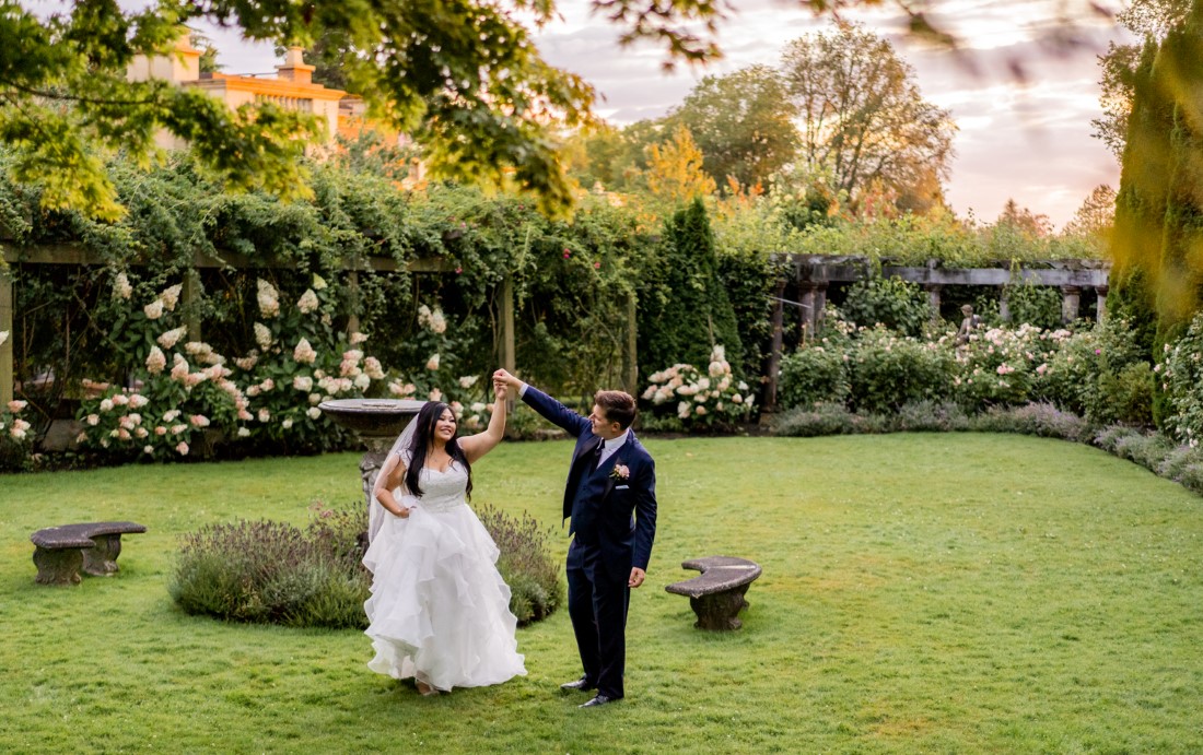 Newlyweds dance in the Rose Garden at Hycroft Manor at UBC